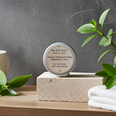 Organic deodorant paste container on a stone block with plants and towel in the background