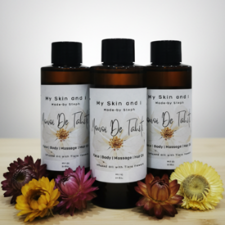 Three bottles of 'My Skin and I' products on a wooden surface with flowers.