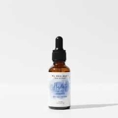 Skincare serum bottle with dropper on a white background